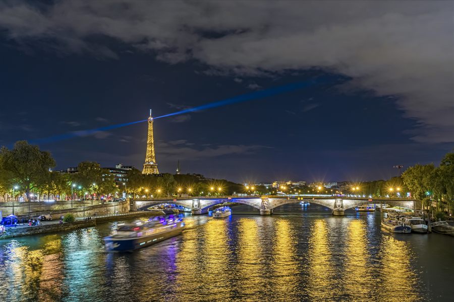Seine river boats at night with the Eiffel Tower